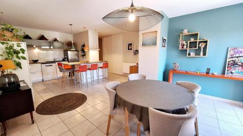 un salon avec une table et une cuisine dans l'établissement L'Appartement de Rémi, Jardin et jacuzzi, à Aigues-Vives