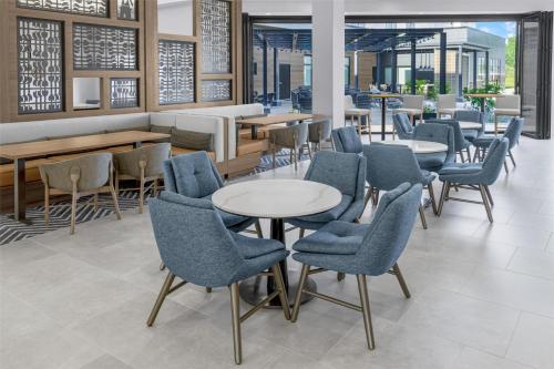 a restaurant with blue chairs and tables and tablesktop at Homewood Suites By Hilton Holland in Holland