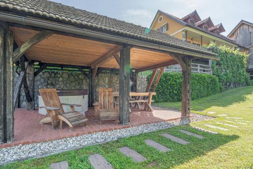 a wooden pavilion with a table and chairs in a yard at Traditional House Kal With Whirlpool - Happy Rentals in Semič