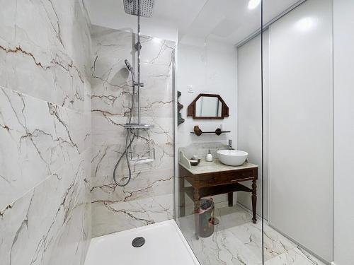 une salle de bain blanche avec une douche et un lavabo dans l'établissement Shangri classé 3 Etoiles Vieux port by laConciergerie13, à La Ciotat