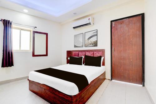 グワーリヤルにあるHotel O Unnati Innのベッドルーム1室(ベッド1台付)、木製のドア