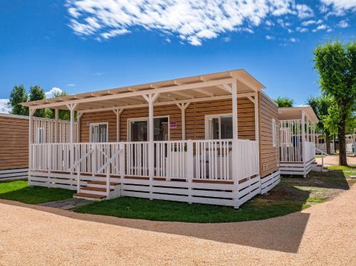 a wooden cabin with a porch and a roof at Club del Sole Jesolo Family Resort in Lido di Jesolo