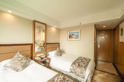 a hotel room with two beds and a table at Huangshan Yupinglou Hotel in Huangshan
