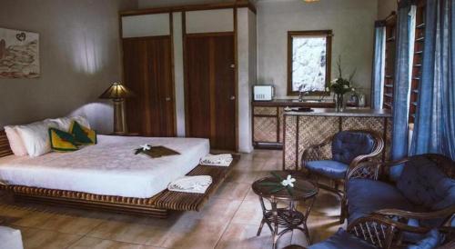 a bedroom with a bed and a living room at Le Manumea Hotel in Apia