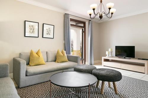 a living room with a couch and a table at Winelands Golf Lodges 12 in Stellenbosch