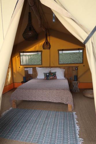 une chambre avec un lit dans une tente dans l'établissement Les Lodges Saint Pierre, au Cap d'Agde