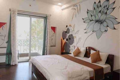 a bedroom with a bed with a flower on the wall at The Dhar Villa in Thūr