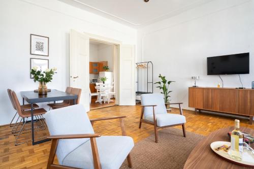 Una sala de estar con una mesa y sillas y un televisor. en Hej Bydgoszcz - Apartament XL na Starym Rynku, en Bydgoszcz