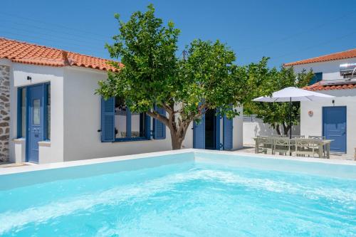 a swimming pool in front of a villa at Koula's Aegina in Perdhika