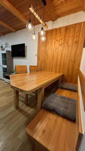 a dining room with a wooden table and a bench at Apartmaji Winter Garden Kranjska Gora in Kranjska Gora