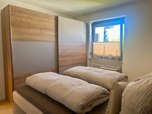 two beds in a room with a window at bergwärts in Bischofsgrün