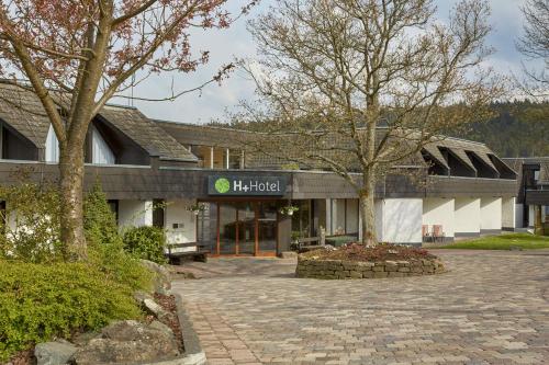 a building with a brick courtyard in front of it at H+ Hotel Willingen in Willingen