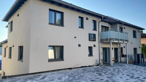 a white building with black windows and a balcony at Boardinghouse Living in Gemmingen