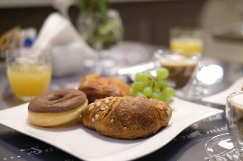 a plate of doughnuts and grapes on a table at LeNotti Verona in Verona