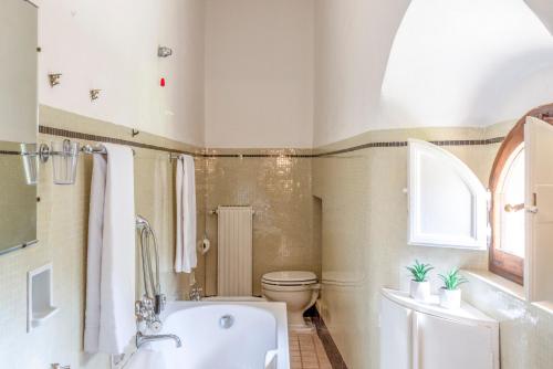a bathroom with a tub and a toilet at TORRE DI PACIANO 10&2, Emma Villas in Paciano