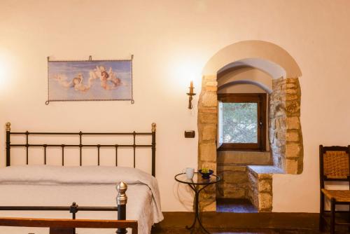 a bedroom with a bed and a window and a staircase at TORRE DI PACIANO 10&2, Emma Villas in Paciano
