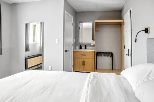 a white bedroom with a white bed and a bathroom at The Mulberry in Logan
