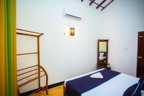 a bedroom with a bed and a mirror at Sanda Villa Kosgoda in Kosgoda