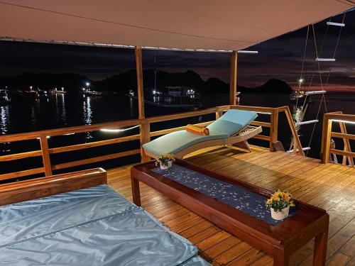 a deck of a boat with a bench and a chair at Luxury Private Phinisi Sailing in Komodo island in Labuan Bajo