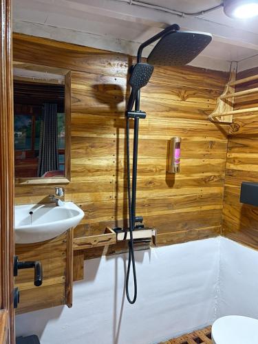 a bathroom with a sink and a shower with wooden walls at Luxury Private Phinisi Sailing in Komodo island in Labuan Bajo