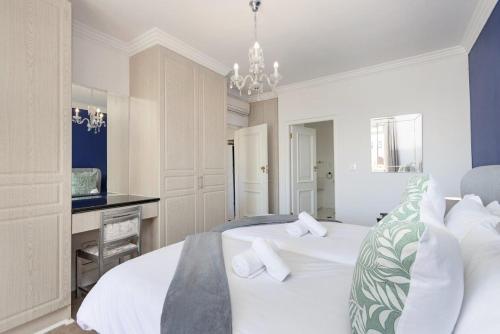 a bedroom with two white beds and a desk at Winelands Golf Lodges 18 in Stellenbosch