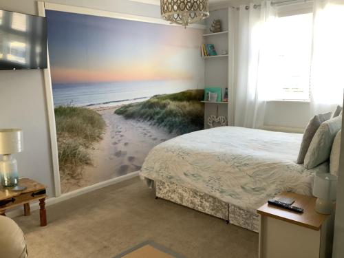 a bedroom with a bed and a beach mural at Awel Y Mor - cosy apartment. in Verwick