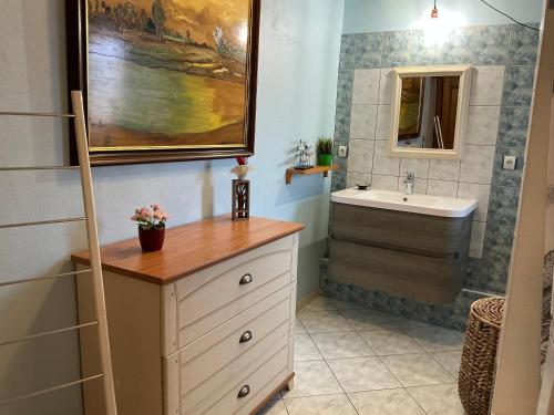 une salle de bain avec un lavabo et un miroir dans l'établissement Le Tokay, à Ribeauvillé