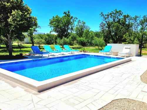 a swimming pool with lounge chairs and a swimming pool at Villa Rosea Domus ZadarVillas in Podlug