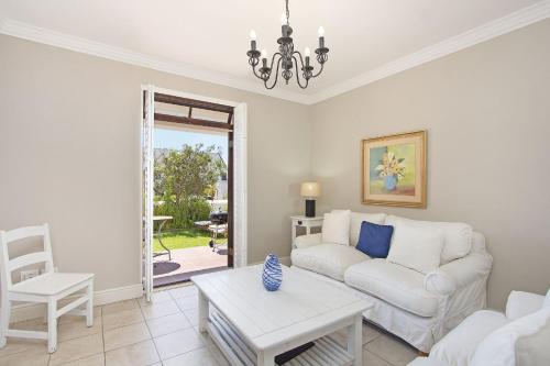 a living room with a white couch and a table at Winelands Golf Lodges 19 in Stellenbosch