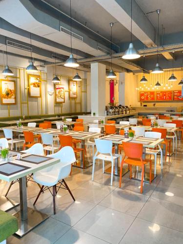 an empty restaurant with tables and chairs and lights at Ayda Mangga Dua ex Zuri Express Mangga Dua in Jakarta