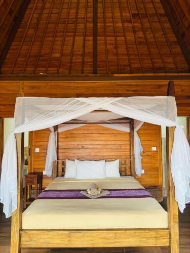 a bed with a canopy in a room at Teba junjungan cottages & villa in Ubud