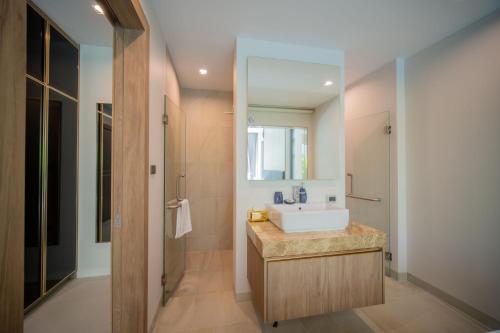 a bathroom with a white sink and a shower at 3BR Villa Z by NLA in Ban Pak Lak