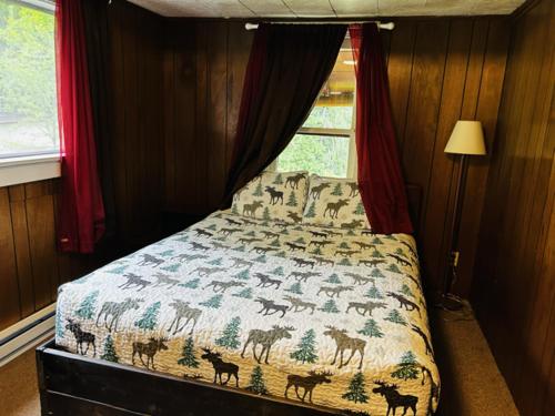 a bedroom with a bed with a blanket with animals on it at Family Cabin at Rainier Lodge -0.4 m from entrance in Ashford