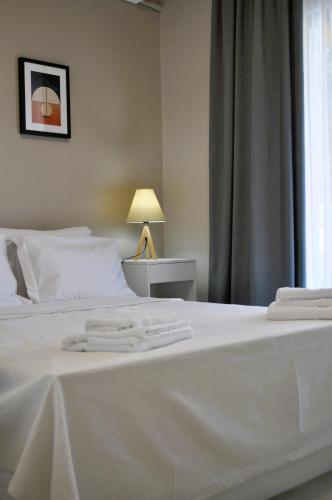 a white bed with two white towels on it at Casa Jasmine in Kavala