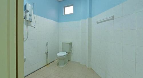 a white bathroom with a toilet and a shower at OYO 90672 De Paradise Turtle Hotel in Kertih