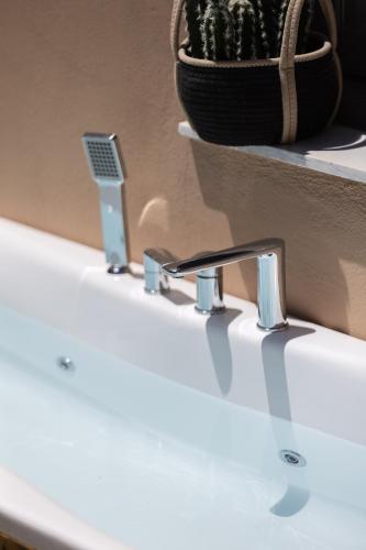 a white sink with two faucets on a counter at Gateway Suites in Rethymno Town