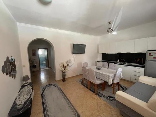 a living room with a table and a kitchen at Anthony&Amar in Berat