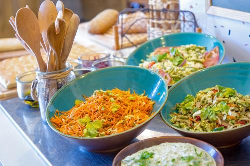 four bowls of food sitting on a counter with other foods at ibis Salon de Provence in Salon-de-Provence