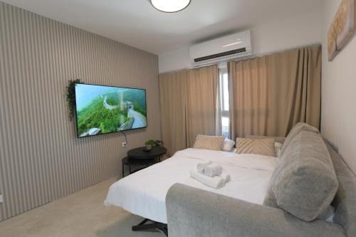 a bedroom with a bed and a tv on a wall at La Bonita Eilat Amazing Pool in Eilat