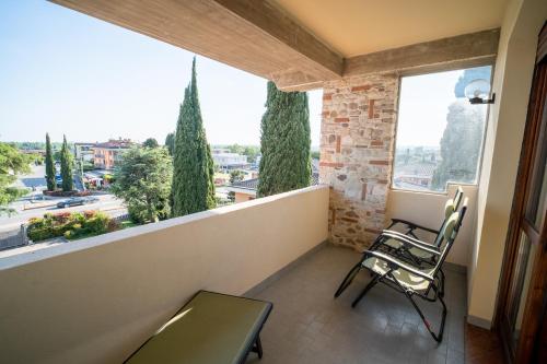 a balcony with two chairs and a view of a city at Hotel Gardenia Sirmione in Sirmione