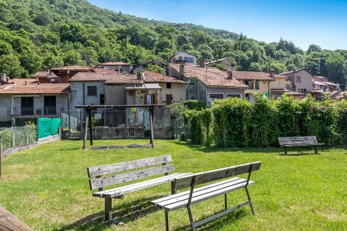 a park bench in front of a town with houses at Residenza Quadrifoglio in Casalzuigno