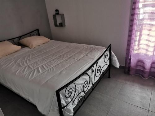 Ce lit se trouve dans une chambre dotée de rideaux violets. dans l'établissement Appartement T2 Marina, à La Tour-de-Salvagny