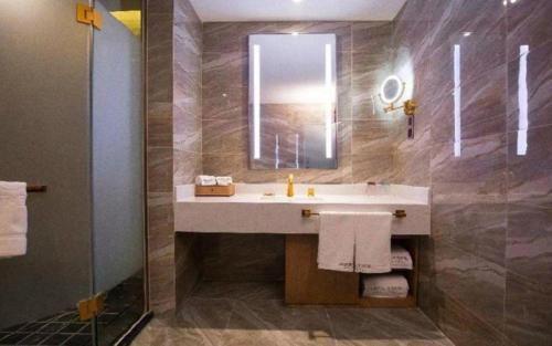 a bathroom with a sink and a mirror at James Joyce Coffetel·Kaifeng Drum Tower in Kaifeng