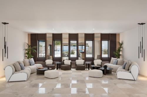 a living room with couches and tables and windows at Vione Paros in Ambelas