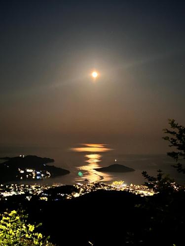 a full moon rising over the water at night at Allure Luxury Villas 2, Skiathos in Skiathos Town