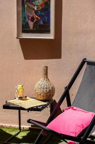 a table with a vase on it next to a chair at Gateway Suites in Rethymno Town