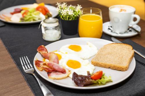 a plate of breakfast food with eggs bacon and toast at Abrazo Sofia Hotel by HMG in Sofia