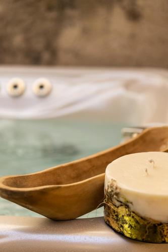 a wooden spoon with a candle next to a bath tub at Gateway Suites in Rethymno Town