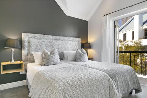 a bedroom with a bed and a large window at Winelands Golf Lodges 24 in Stellenbosch