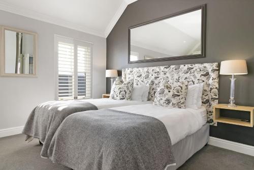 a bedroom with two beds and a large mirror at Winelands Golf Lodges 24 in Stellenbosch